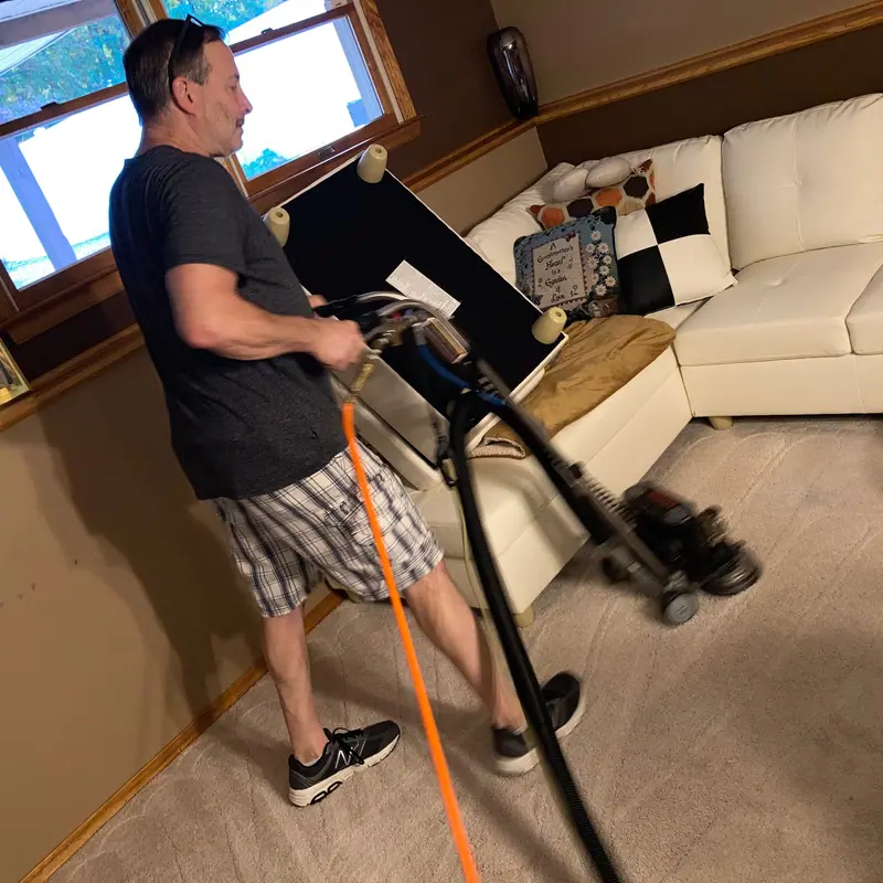 Miracle Men technician cleaning carpet in a finished basement