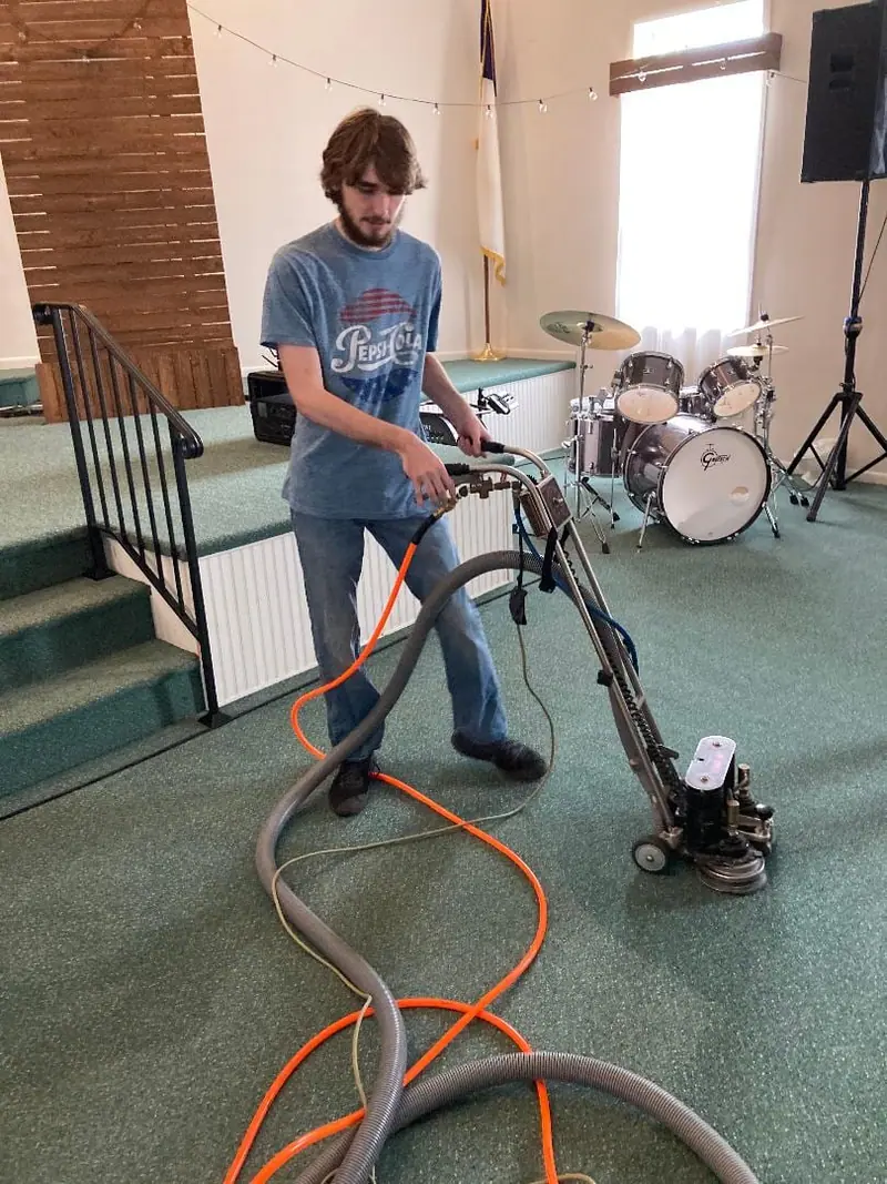 Cleaning green carpet on a church stage