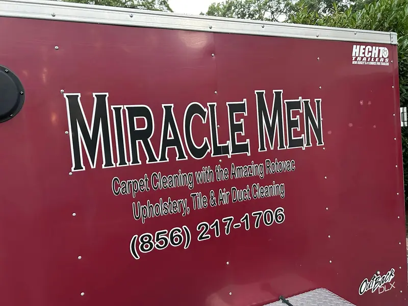 The Miracle Men burgundy work trailer, lettered with Carpet Cleaning with the Amazing Rotovac, Upholstery, Tile and Air Duct Cleaning, and (856) 217-1706